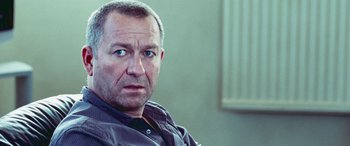 Movie still from “4.3.2.1.” (2010), directed by Mark Davis – A person wearing a shirt; Close Up shot, Over the shoulder angle