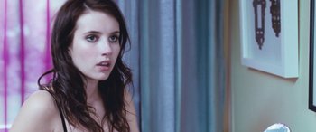 Movie still from “4.3.2.1.” (2010), directed by Mark Davis – A beautiful young lady sitting in front of a blue curtain; Close Up shot, Over the shoulder angle