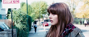 Movie still from “4.3.2.1.” (2010), directed by Mark Davis – A woman standing on the side of a road; Close Up shot, Over the shoulder angle