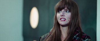 Movie still from “4.3.2.1.” (2010), directed by Mark Davis – A person wearing a jacket with blood all over her face; Close Up shot, Over the shoulder angle