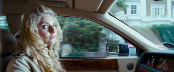Movie still from “4.3.2.1.” (2010), directed by Mark Davis – A woman sitting in the passenger seat of a car looking out the window; Close Up shot, Over the shoulder angle