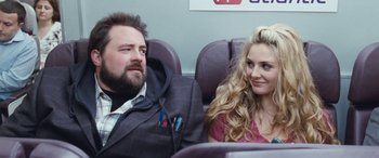 Movie still from “4.3.2.1.” (2010), directed by Mark Davis – A man and a woman sitting next to each other on a plane; Close Up shot, Over the shoulder angle