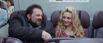 Movie still from “4.3.2.1.” (2010), directed by Mark Davis – A man and a woman sitting on a plane; Close Up shot, Over the shoulder angle