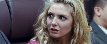 Movie still from “4.3.2.1.” (2010), directed by Mark Davis – A person with long blonde hair; Close Up shot, Over the shoulder angle