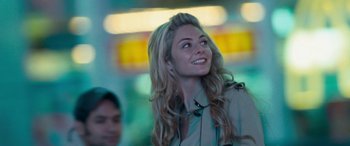 Movie still from “4.3.2.1.” (2010), directed by Mark Davis – A beautiful blonde woman with long hair smiling for the camera; Close Up shot, Low angle