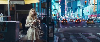 Movie still from “4.3.2.1.” (2010), directed by Mark Davis – A woman standing on the side of the street at night; Wide shot, High angle