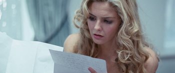 Movie still from “4.3.2.1.” (2010), directed by Mark Davis – A beautiful blonde woman holding a piece of paper in her hands; Close Up shot, Over the shoulder angle