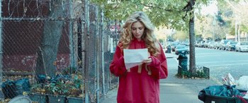 Movie still from “4.3.2.1.” (2010), directed by Mark Davis – A woman standing on the side of the street looking at a piece of paper; Medium shot, Low angle