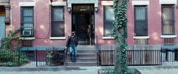 Movie still from “4.3.2.1.” (2010), directed by Mark Davis – A man walking down the steps of a house; Wide shot, High angle