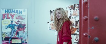 Movie still from “4.3.2.1.” (2010), directed by Mark Davis – A woman with long blonde hair standing in front of a wall; Medium shot, Over the shoulder angle