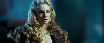 Movie still from “4.3.2.1.” (2010), directed by Mark Davis – A woman with long blonde hair wearing a black jacket; Close Up shot, Over the shoulder angle