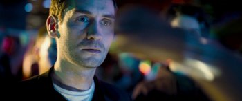 Movie still from “4.3.2.1.” (2010), directed by Mark Davis – A person wearing a white shirt; Close Up shot, Low angle