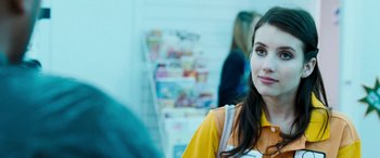 Movie still from “4.3.2.1.” (2010), directed by Mark Davis – A woman in a yellow shirt is smiling for the camera; Close Up shot, Over the shoulder angle
