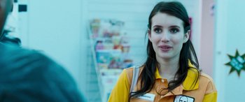 Movie still from “4.3.2.1.” (2010), directed by Mark Davis – A woman standing in front of a wall of books; Close Up shot, Over the shoulder angle