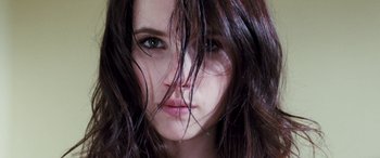 Movie still from “4.3.2.1.” (2010), directed by Mark Davis – A woman's face with long brown hair; Close Up shot, Low angle