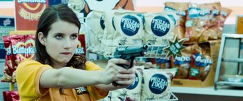 Movie still from “4.3.2.1.” (2010), directed by Mark Davis – A woman holding a gun in front of a display of potato chips; Close Up shot, Over the shoulder angle