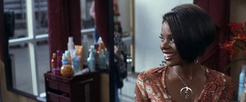 Movie still from “50 First Dates” (2004), directed by Peter Segal – A woman smiles brightly while sitting in front of a mirror; Close Up shot, Over the shoulder angle
