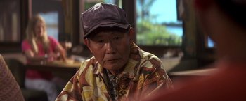 Movie still from “50 First Dates” (2004), directed by Peter Segal – An older man wearing a hat sitting in a room; Close Up shot, Over the shoulder angle