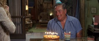 Movie still from “50 First Dates” (2004), directed by Peter Segal – An older man sitting in front of a birthday cake; Medium shot, High angle