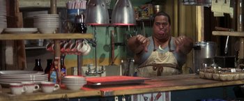 Movie still from “50 First Dates” (2004), directed by Peter Segal – A man in an apron in front of a counter; Close Up shot, Over the shoulder angle