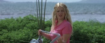 Movie still from “50 First Dates” (2004), directed by Peter Segal – A woman in a pink shirt is holding a bag; Medium shot, Low angle