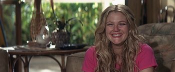 Movie still from “50 First Dates” (2004), directed by Peter Segal – A woman smiling for the camera in front of a plant; Close Up shot, Over the shoulder angle