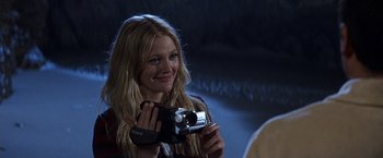 Movie still from “50 First Dates” (2004), directed by Peter Segal – A woman is holding a camera and smiling for a picture; Close Up shot, Over the shoulder angle