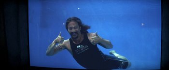 Movie still from “50 First Dates” (2004), directed by Peter Segal – A man in a black tank top is swimming underwater; Medium shot, High angle