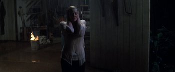 Movie still from “50 First Dates” (2004), directed by Peter Segal – A woman standing in the dark with her hands behind her head; Medium shot, Low angle