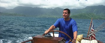 Movie still from “50 First Dates” (2004), directed by Peter Segal – A man sitting at the steering wheel of a boat in the water; Medium shot, High angle