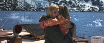 Movie still from “50 First Dates” (2004), directed by Peter Segal – Two young girls hugging on a boat in the water; Medium shot, High angle
