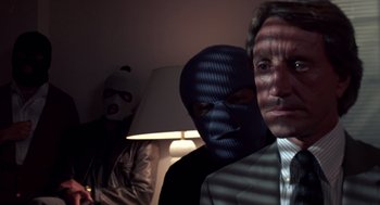 Movie still from “52 Pick-Up” (1986), directed by John Frankenheimer – Three men in suits and masks in front of a lamp; Close Up shot, Low angle