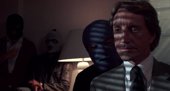 Movie still from “52 Pick-Up” (1986), directed by John Frankenheimer – Three men in masks and suits are posing for a picture; Close Up shot, Low angle