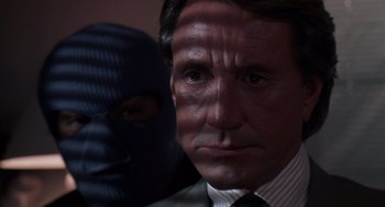 Movie still from “52 Pick-Up” (1986), directed by John Frankenheimer – A person wearing a suit and tie; Close Up shot, Low angle