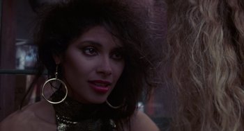 Movie still from “52 Pick-Up” (1986), directed by John Frankenheimer – A person wearing a gold top; Close Up shot, Over the shoulder angle