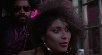 Movie still from “52 Pick-Up” (1986), directed by John Frankenheimer – A person with a person in the background; Close Up shot, Low angle