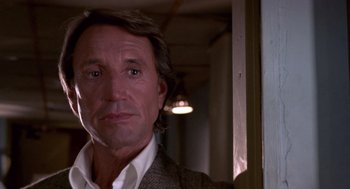 Movie still from “52 Pick-Up” (1986), directed by John Frankenheimer – A person wearing a suit and tie; Close Up shot, Low angle