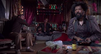 Movie still from “52 Pick-Up” (1986), directed by John Frankenheimer – A group of people sitting in a living room together; Wide shot, Low angle