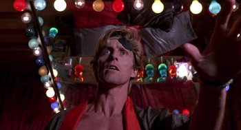 Movie still from “52 Pick-Up” (1986), directed by John Frankenheimer – A person wearing a red shirt; Close Up shot, Low angle