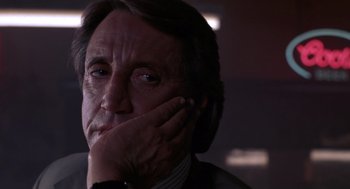 Movie still from “52 Pick-Up” (1986), directed by John Frankenheimer – A person with his hand on his face; Close Up shot, Low angle