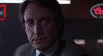 Movie still from “52 Pick-Up” (1986), directed by John Frankenheimer – An older man wearing a suit and a tie; Close Up shot, Low angle