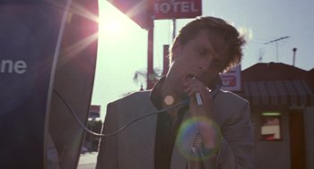 Movie still from “52 Pick-Up” (1986), directed by John Frankenheimer – A man in a suit talking on a phone; Close Up shot, Low angle