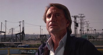 Movie still from “52 Pick-Up” (1986), directed by John Frankenheimer – A person wearing a suit and tie; Close Up shot, Low angle