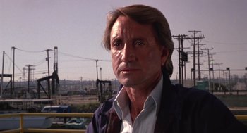 Movie still from “52 Pick-Up” (1986), directed by John Frankenheimer – A person wearing a suit and tie; Close Up shot, Low angle