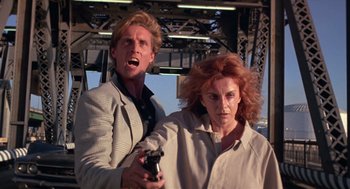 Movie still from “52 Pick-Up” (1986), directed by John Frankenheimer – A man and a woman holding a video game controller; Close Up shot, Low angle
