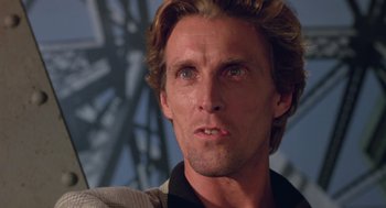 Movie still from “52 Pick-Up” (1986), directed by John Frankenheimer – A man with long blonde hair; Close Up shot, Low angle