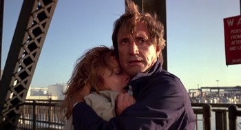 Movie still from “52 Pick-Up” (1986), directed by John Frankenheimer – A man and a little girl hugging each other; Close Up shot, Low angle