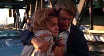 Movie still from “52 Pick-Up” (1986), directed by John Frankenheimer – A man and a woman hugging each other; Close Up shot, Low angle