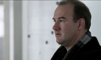 Movie still from “71 Fragments of a Chronology of Chance” (1994), directed by Michael Haneke – A person looking at the camera; Close Up shot, Over the shoulder angle