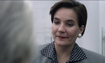 Movie still from “71 Fragments of a Chronology of Chance” (1994), directed by Michael Haneke – A person with short hair wearing a jacket; Close Up shot, Over the shoulder angle